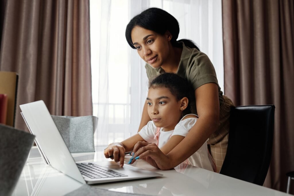 alt="A women and a young girl working on a laptop computer together, a representation of education galaxy"