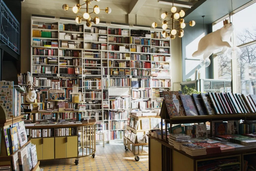 alt="a book store filled with affordable education books with sun light streaming in through the glass windows"