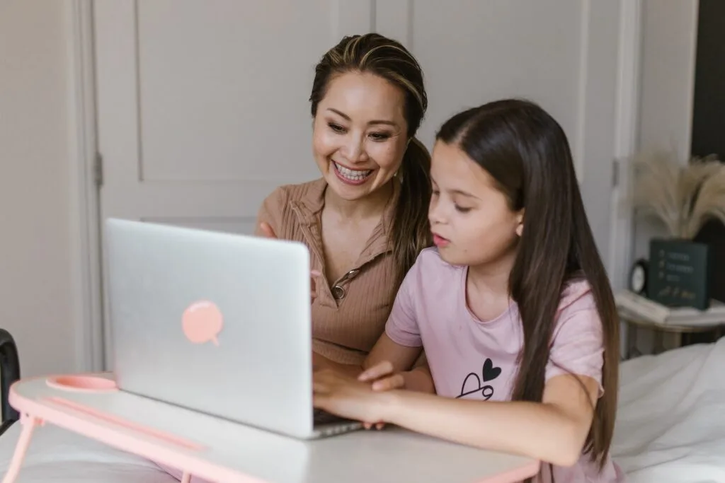 alt="a mother and daughter sitting together in front of a computer having an alternative education session"