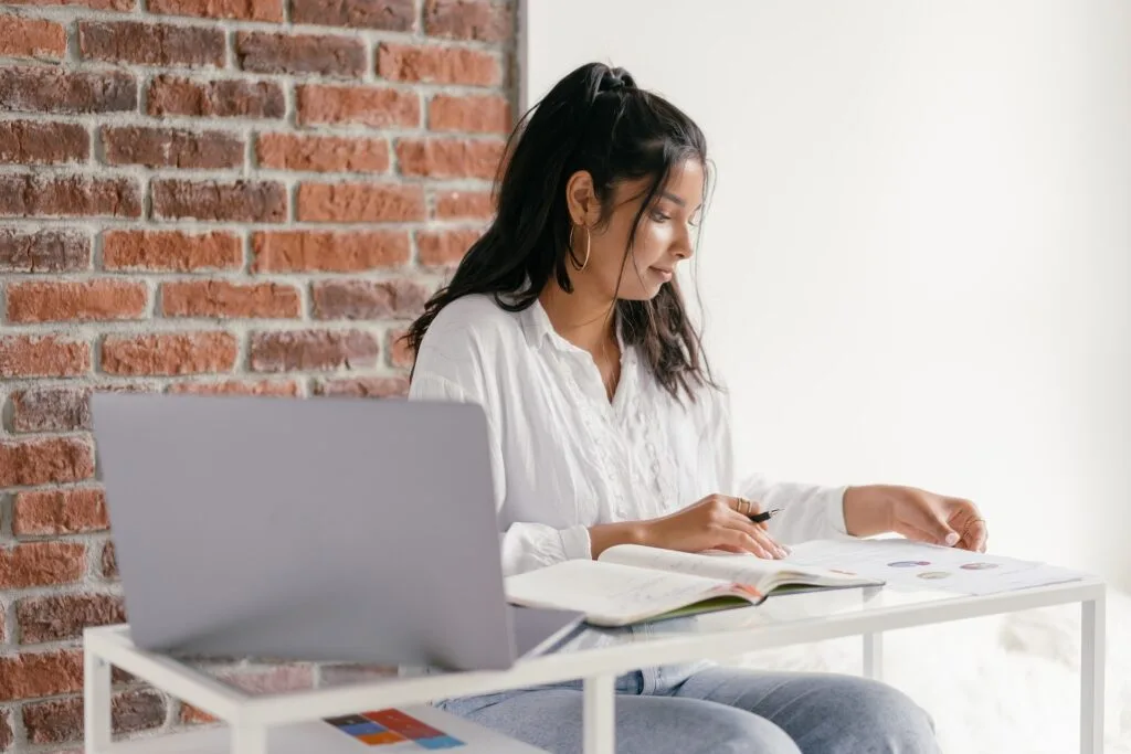 alt="A student with an open laptop studying a book as part of education dynamics"