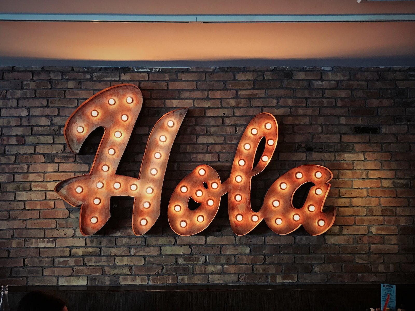 alt="A sign that spells out the word "Hola", part of Education in Spanish"