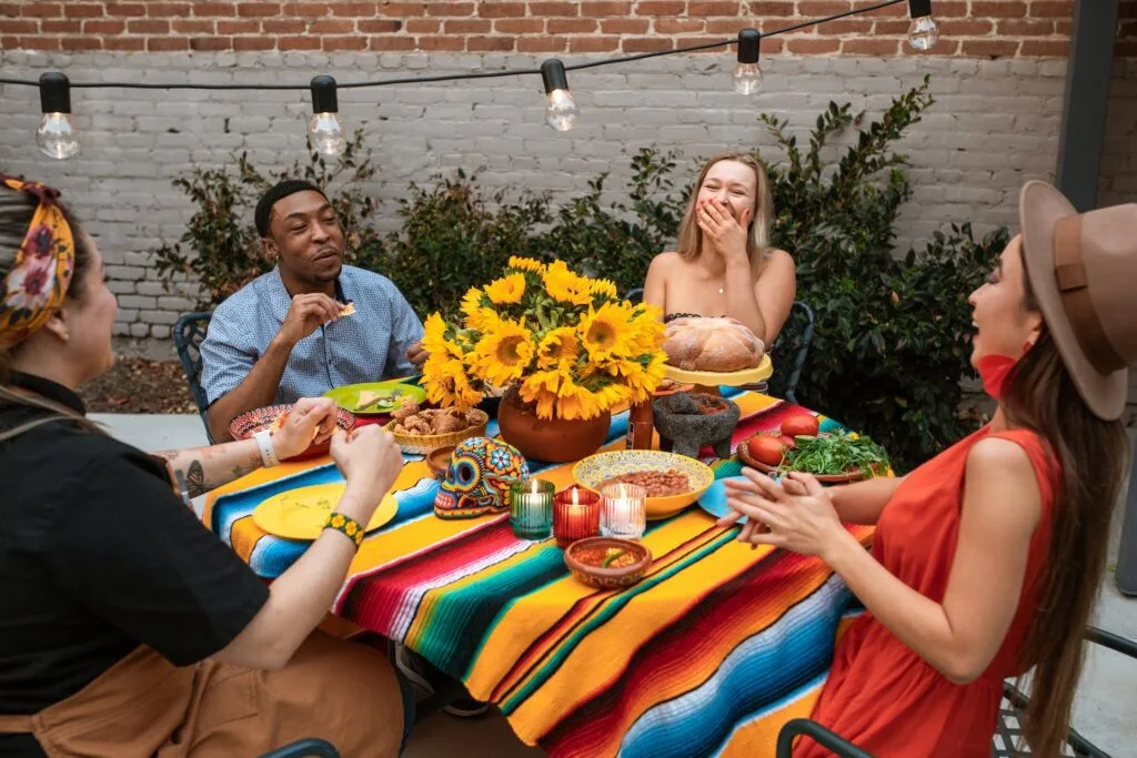 alt="A group of people sitting around a table eating together, part of education in Spanish"