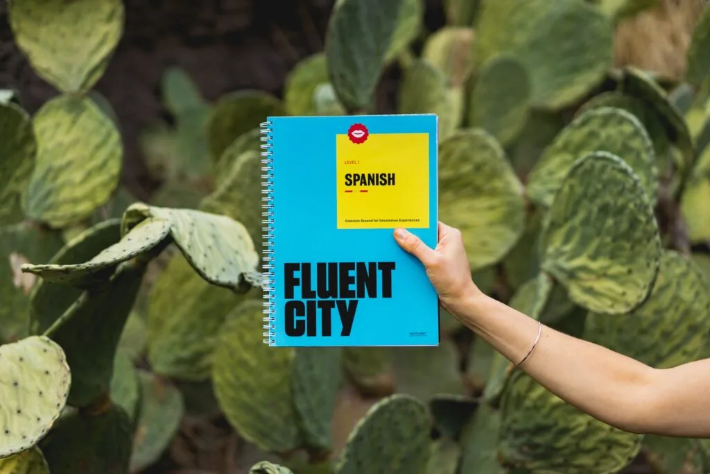 alt="A hand holding a Spanish guide book, part of education in Spanish"