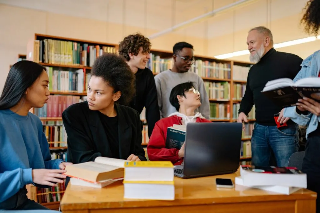 alt="A adult providing support to a group of students as part of education icon"