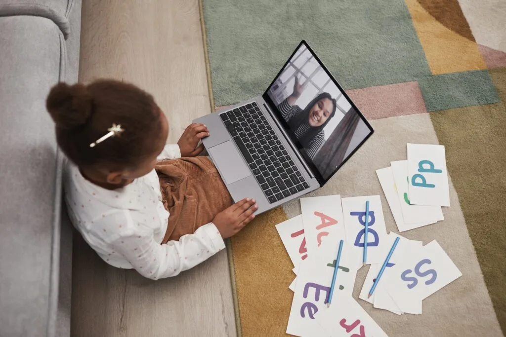 alt="A young student studying with a laptop and flash cards as part of education in Spanish"